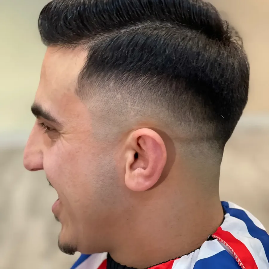Herrenhaarschnitt mit Pompadour und rasiertem &Uuml;bergang.