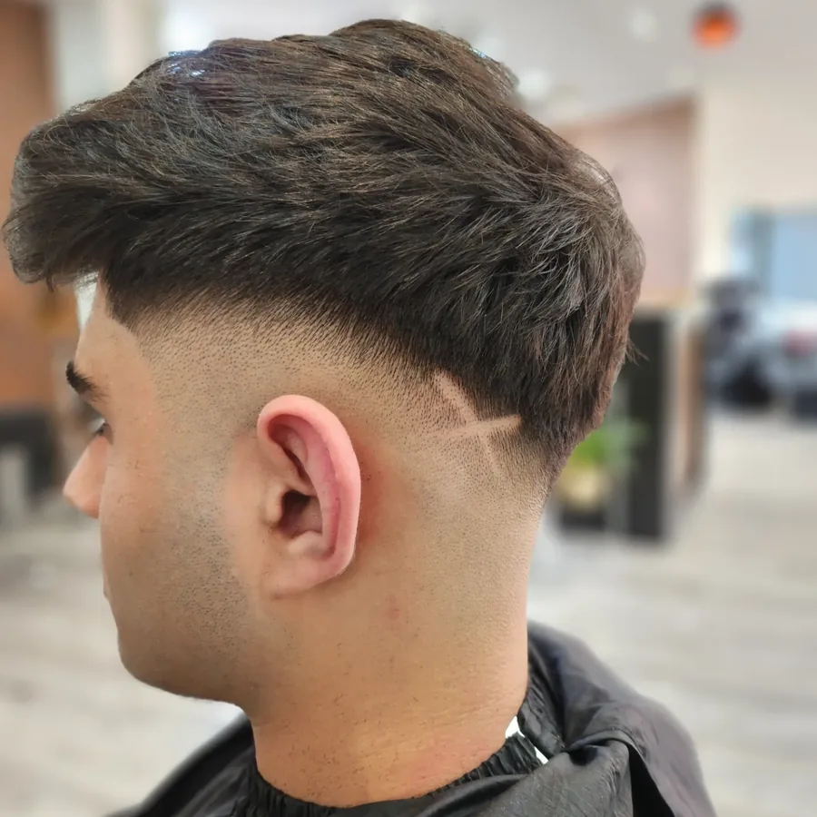 Moderner Herrenhaarschnitt mit Textur im Deckhaar und kurzen Seiten.